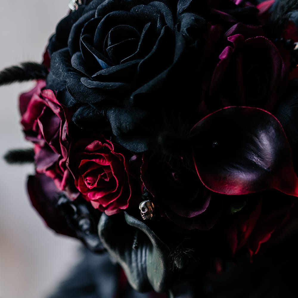 Black & red rose bridal bouquet with mini silver skull decor 