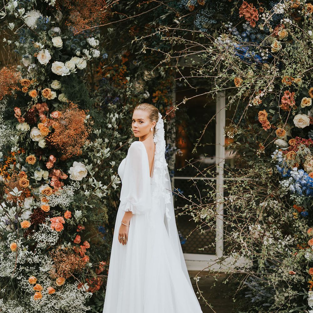 Bride in white wedding dress with sheer balloon sleeves with flower veil 