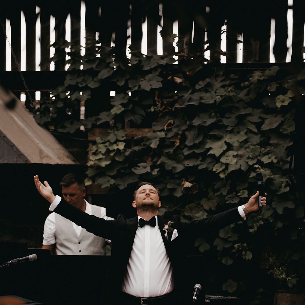 Groom stands up reading out his wedding speech in a classic and traditional black tie 