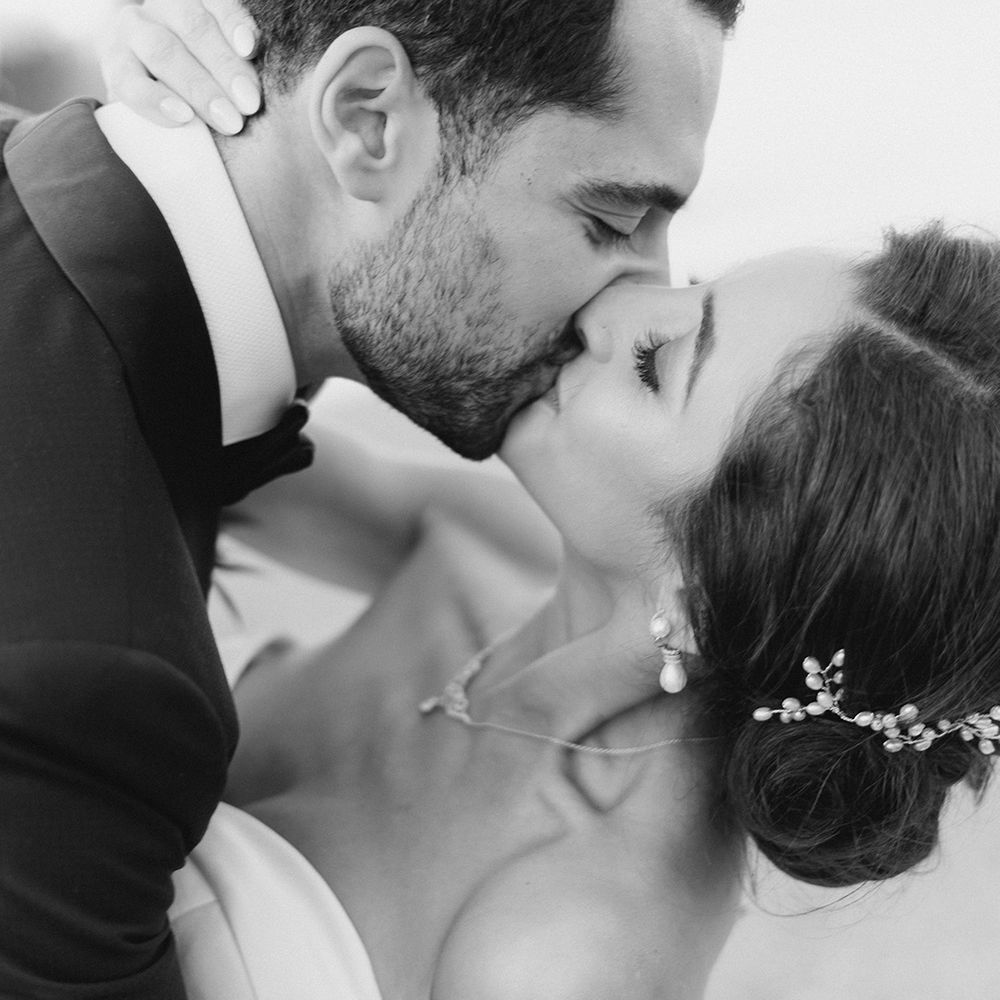 Groom dips his bride for a kiss in black & white image for couples portraits 