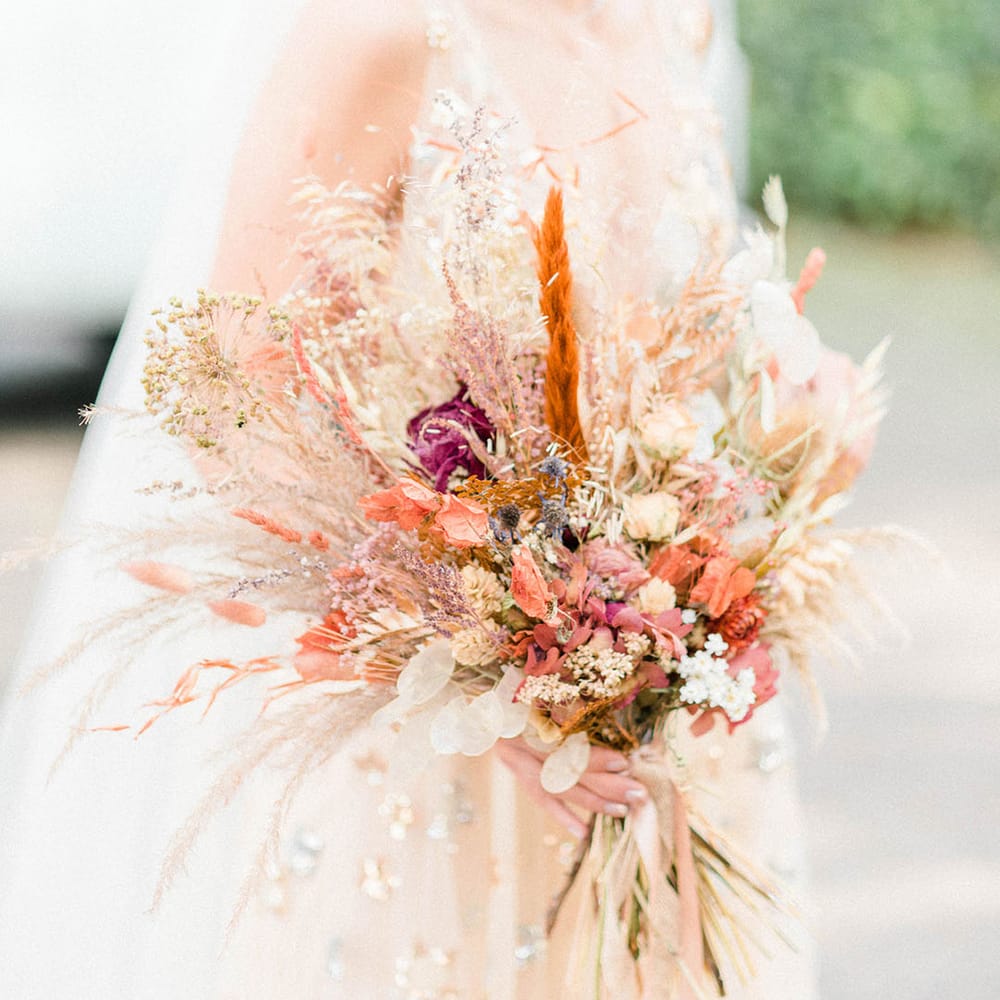 Blonde bride carries Autumnal dried floral bouquet on the morning of her wedding day