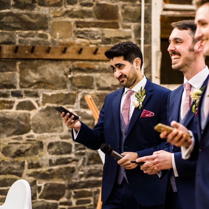 Groomsmen wear three piece suits complete with pink ties and floral buttonholes 