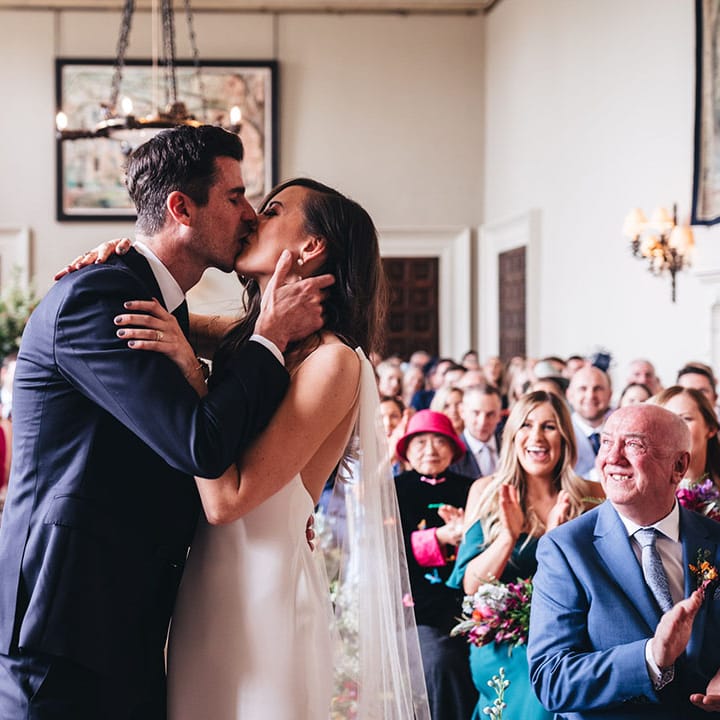 Bride in a Kyha wedding dress shares her first kiss with the groom as a married couple at Elmore Court 