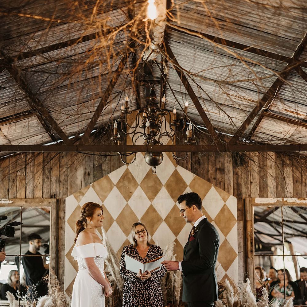 Bride & groom marry during bespoke ceremony at The Dreys wedding venue surrounded by Autumnal dried floral arrangements