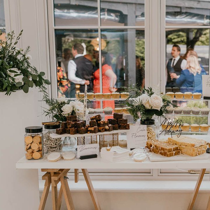 Dessert table and station with cupcakes, brownies, chocolates, biscuits, and pretzels 