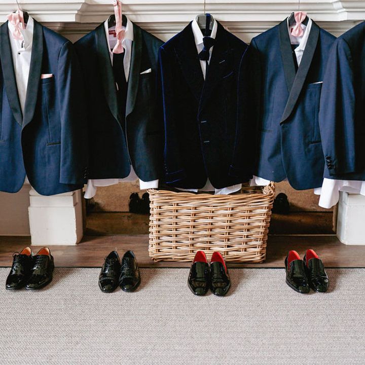 The groom and groomsmen's tuxedo jackets and shoes lined up for them 