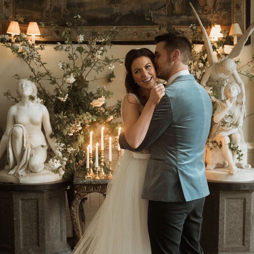 Bride in tulle wedding dress with groom in blue velvet blazer at their cosy intimate wedding ceremony 