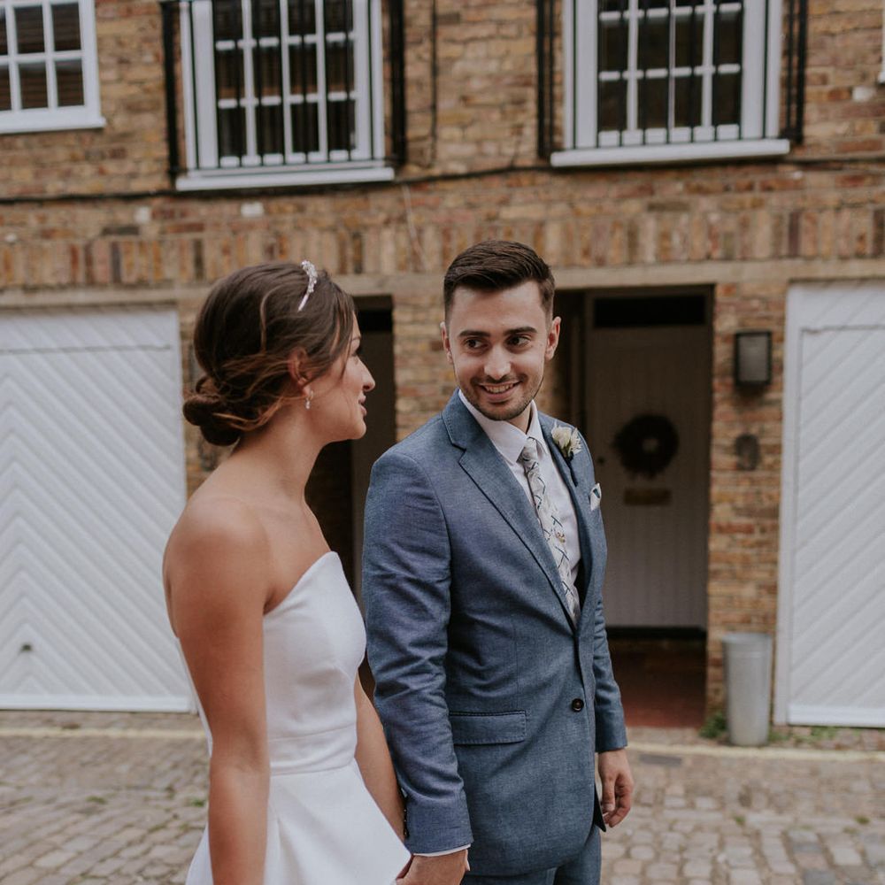 Bride in Roland Mouret wedding dress holding hands with her groom
