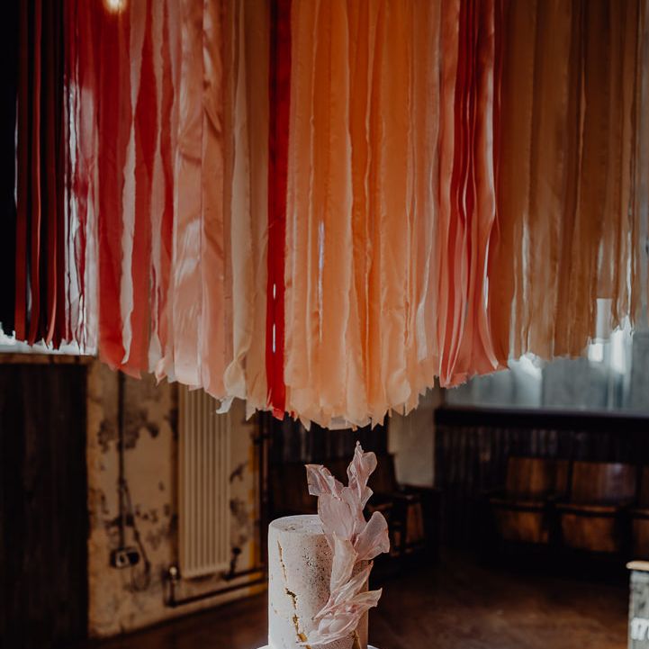 Single tier wedding cake with streamer backdrop 