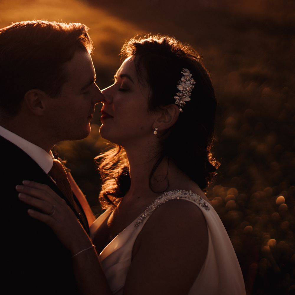 Bride & groom kiss during golden hour