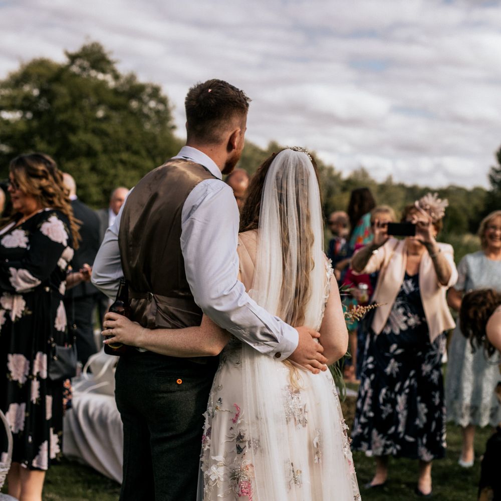 Bride & groom in front of wedding party 