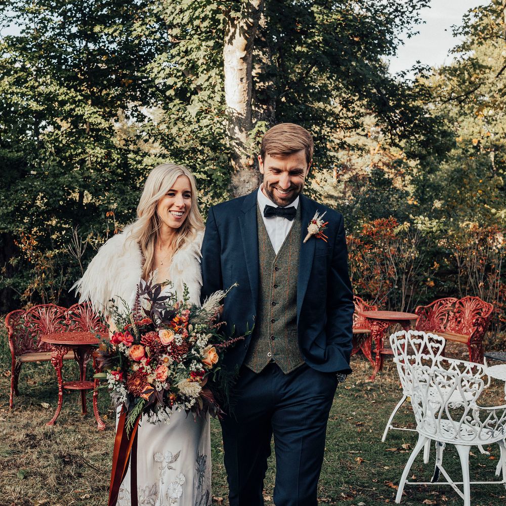 Blonde bride stands with groom wearing blue suit on wedding day 