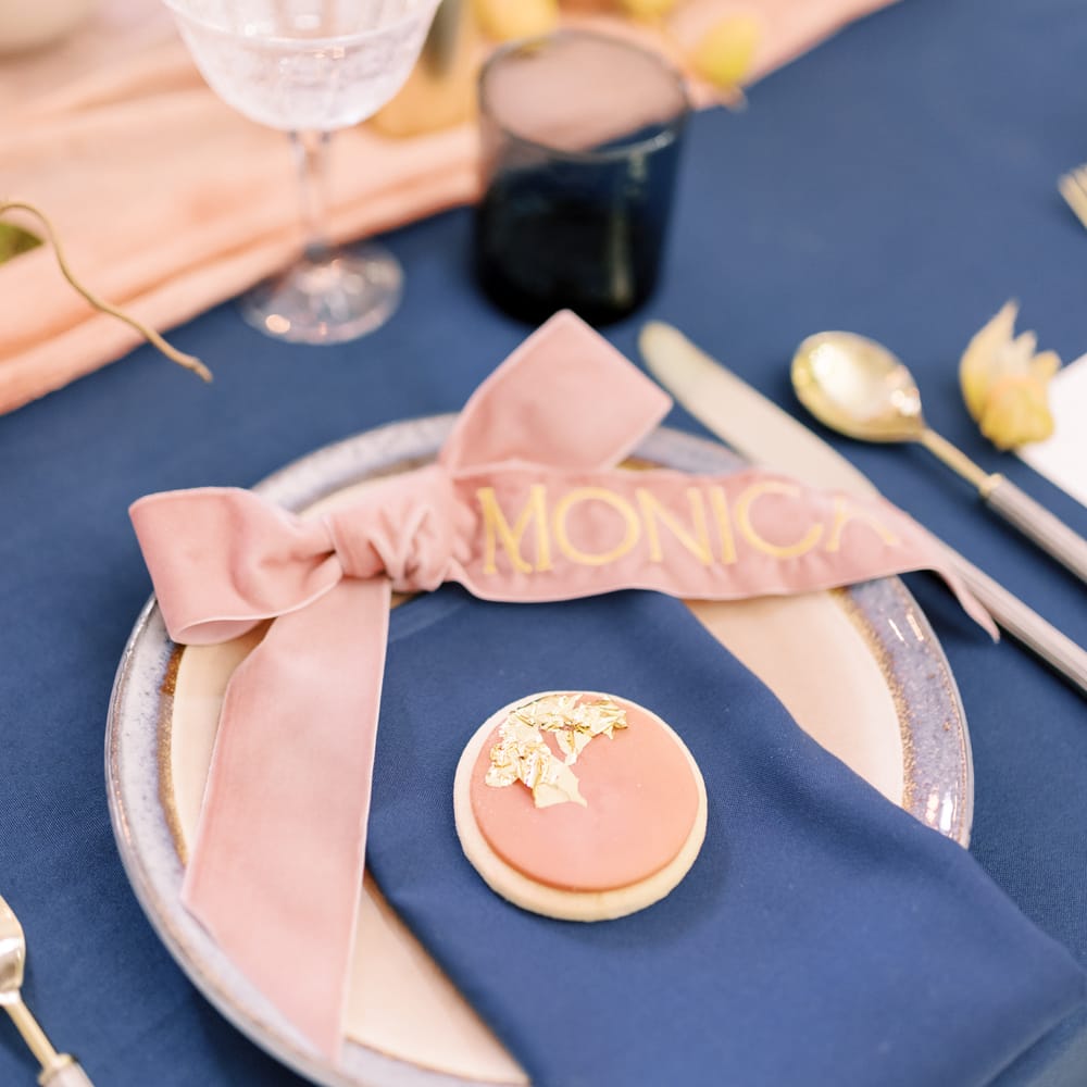 Tablescape complete with pastel pink biscuit favours complete with gold leaf on blue napkins
