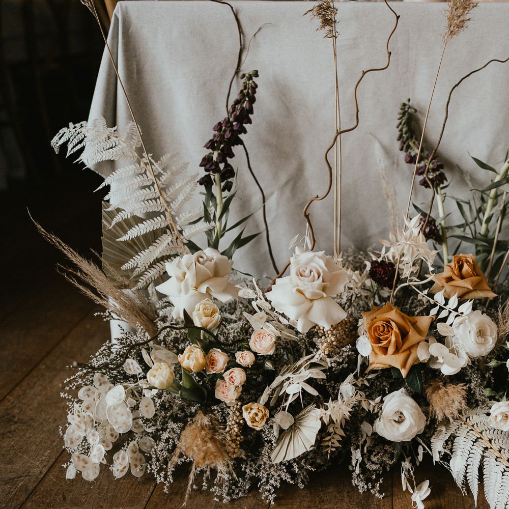 Dried and fresh flower arrangements with twisted willow and frilly caramel toned garden roses