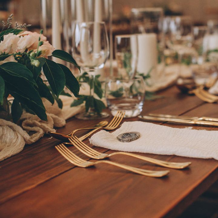 Wedding table place setting with linen napkins and gold cutlery