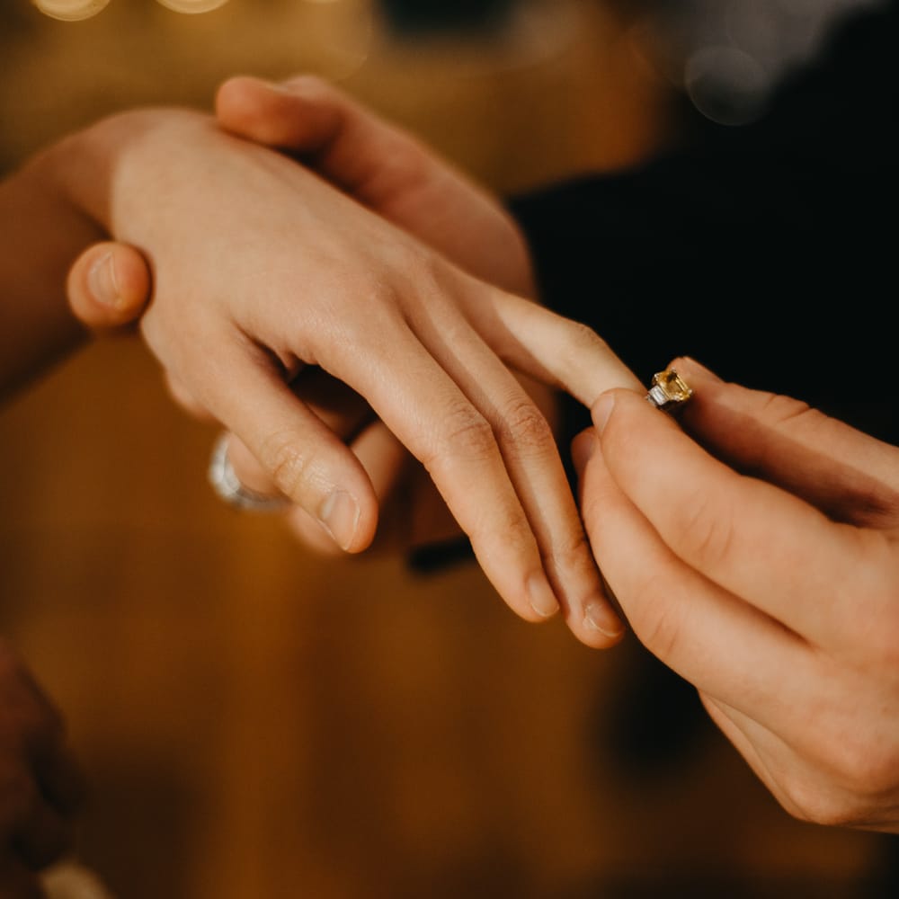 Groom puts vintage wedding ring on brides finger at Wellbeing Farm wedding 