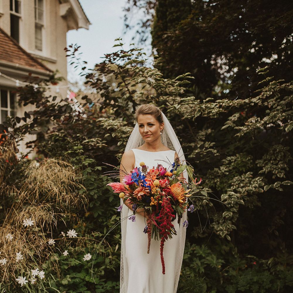 Beautiful bride in a Charlie Brear wedding dress with high neck and polka dot cathedral length Rebecca Anne Designs wedding veil 