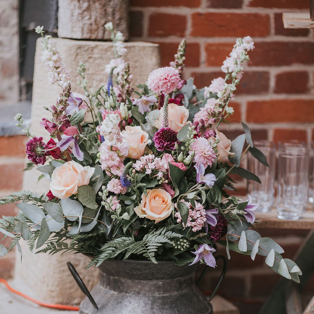 Assorted flower display of orange, pink, white and purple including roses and gladiolus with greenery 