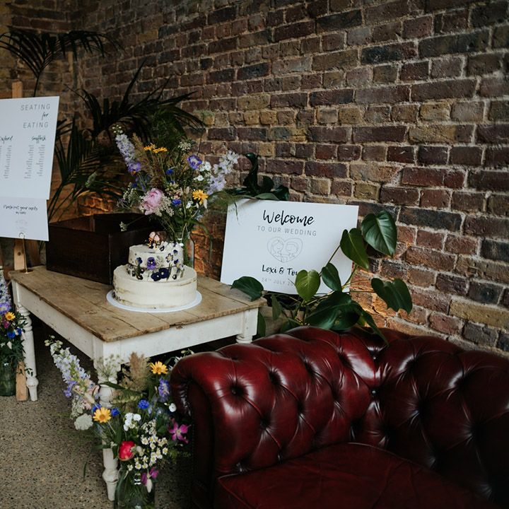 Welcome wedding sign with seating chart and colourful wildflower wedding bouquets with semi naked two tier wedding cake 
