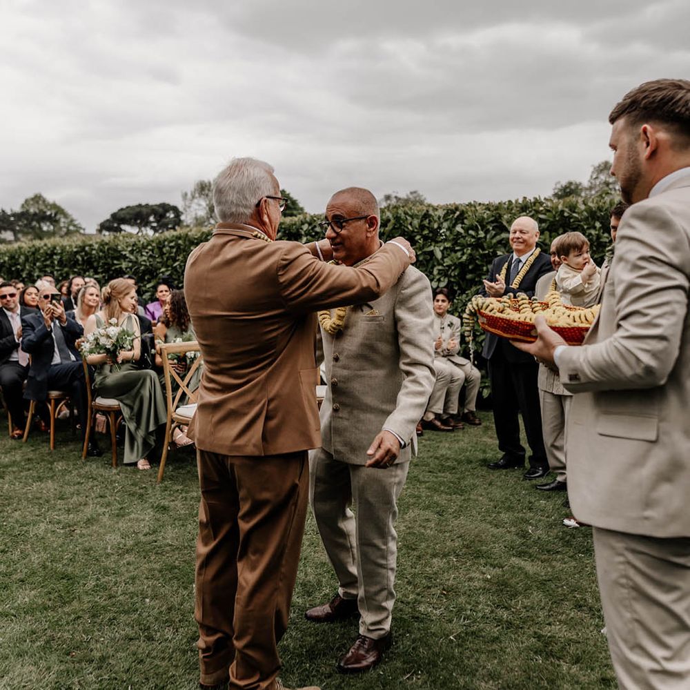 Milni ritual at outdoor multicultural wedding with yellow flower garlands 