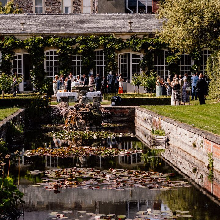 Wedding guests socialise outside together at the Goldney Hall wedding venue