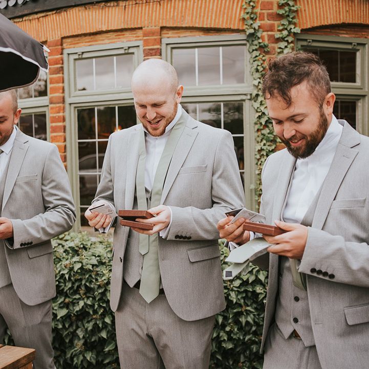 Groomsmen open a wedding gift to them on the morning of the wedding 