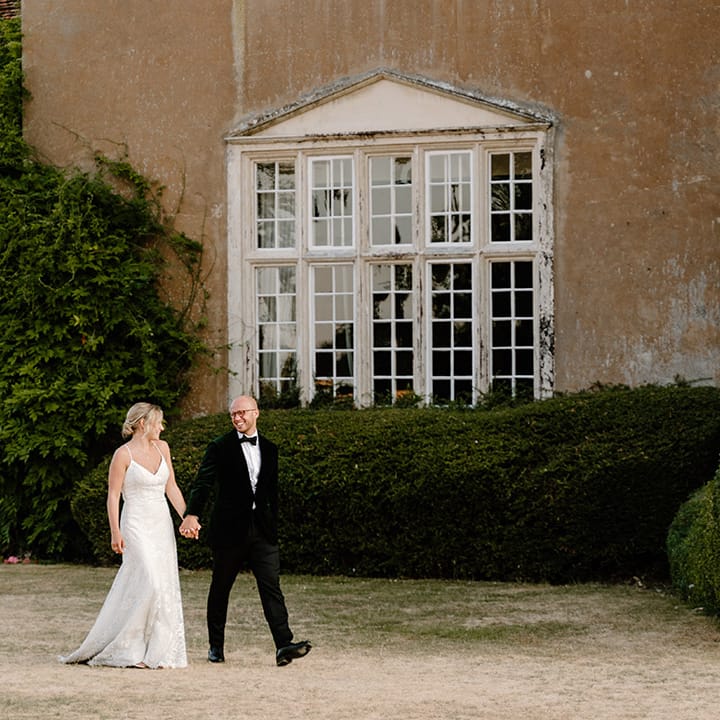 Bride & groom walk outdoors at Bisham Abbey after wedding ceremony