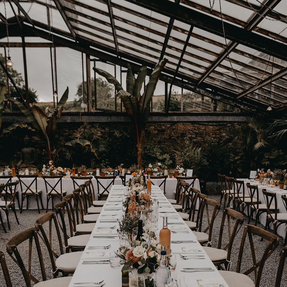 Large banquet table decorated with pastel flowers, plants and lemon for South of France inspired wedding at a glasshouse wedding venue 