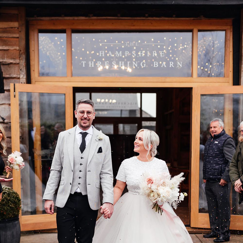 Silchester Farm winter wedding with the bride and groom walking out of their ceremony to confetti 