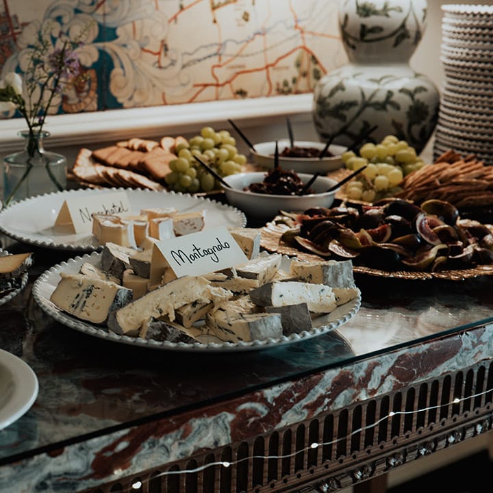 Sharing food platters and charcuterie boards of different cheeses, fruit and crackers 