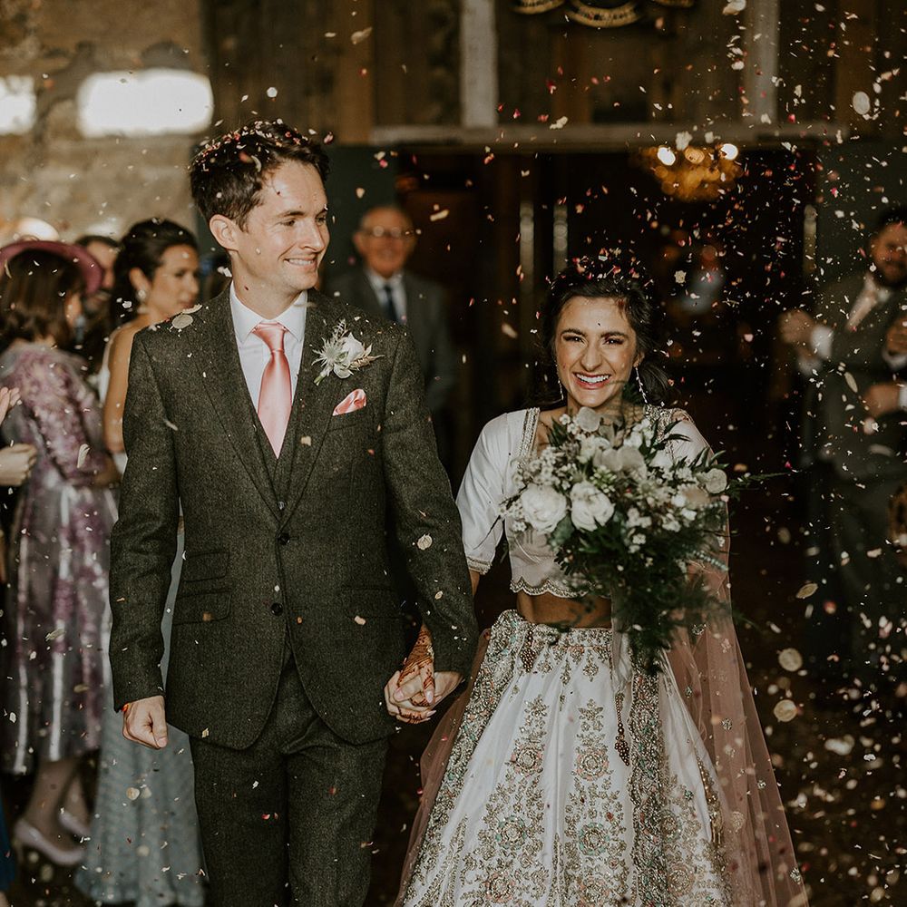 Dried petal confetti moment for bride and groom as they walk out of the ceremony 