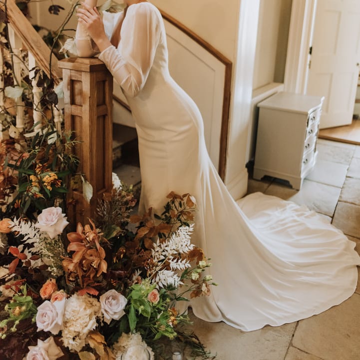 Bride wears sleek long sleeve simple wedding dress at Reymerston Hall