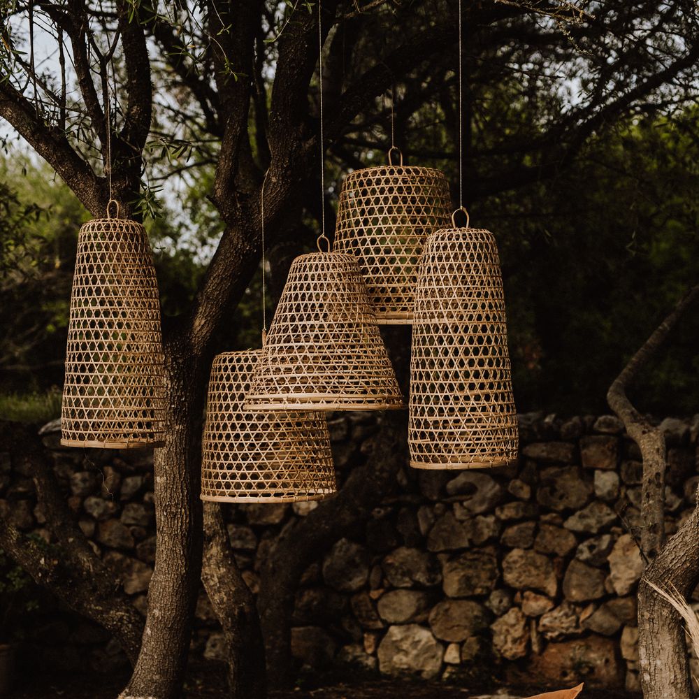 Outdoor wicker lampshades with woven bed outdoors