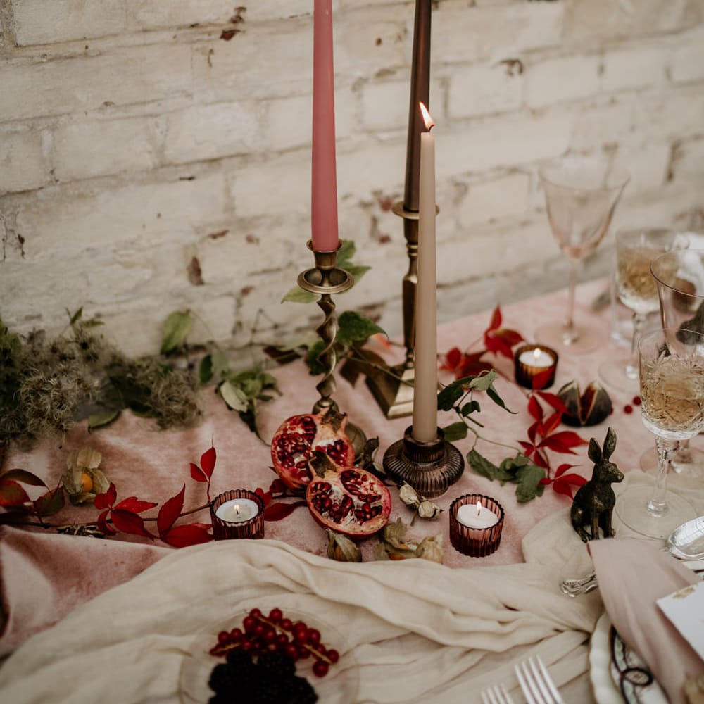 Candlestick and taper candle wedding table decor with votives and figs 
