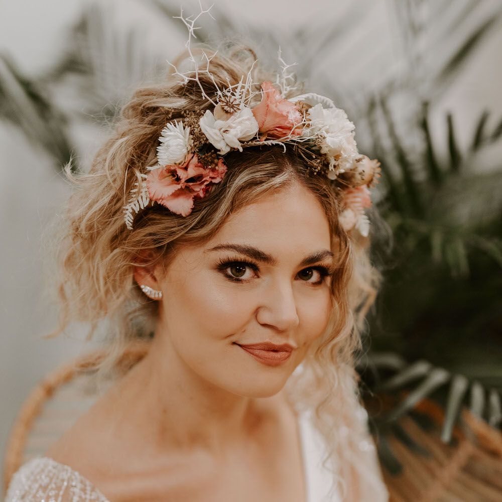 Bride with wavy beach curl wedding hair, a tropical hairband and neutral glowy makeup
