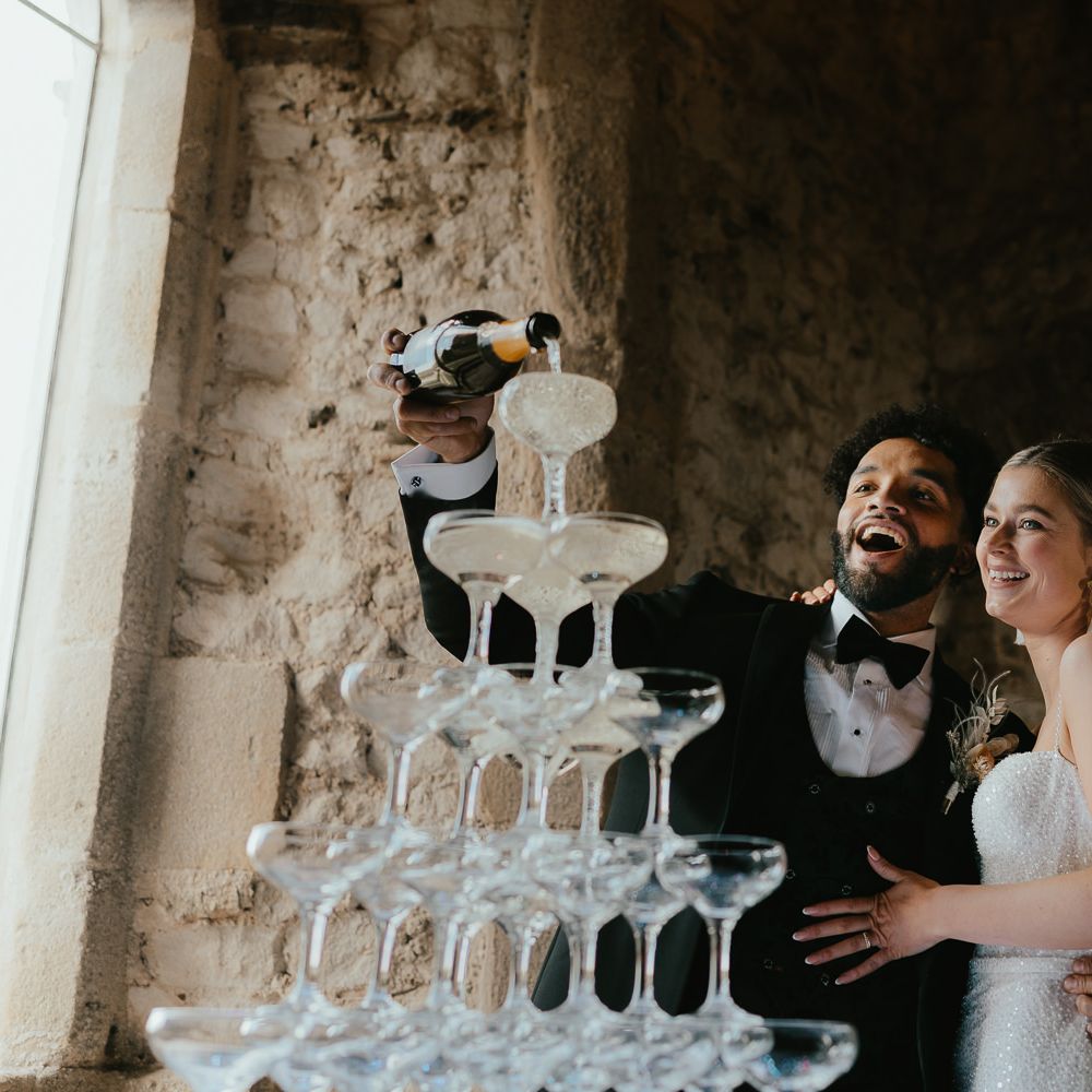 Groom pouring into a champagne tower 