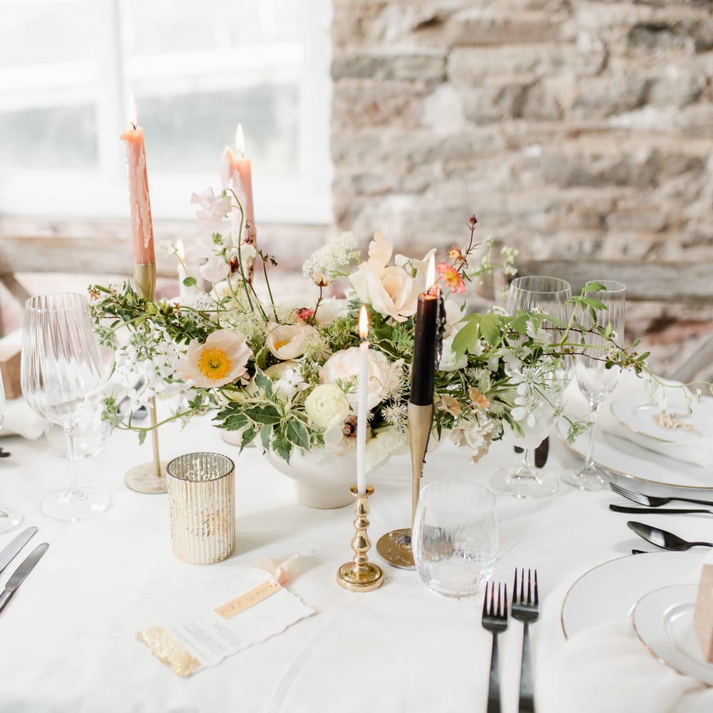 Elegant wedding table decor with gold candlesticks, and gold rimmed tableware 
