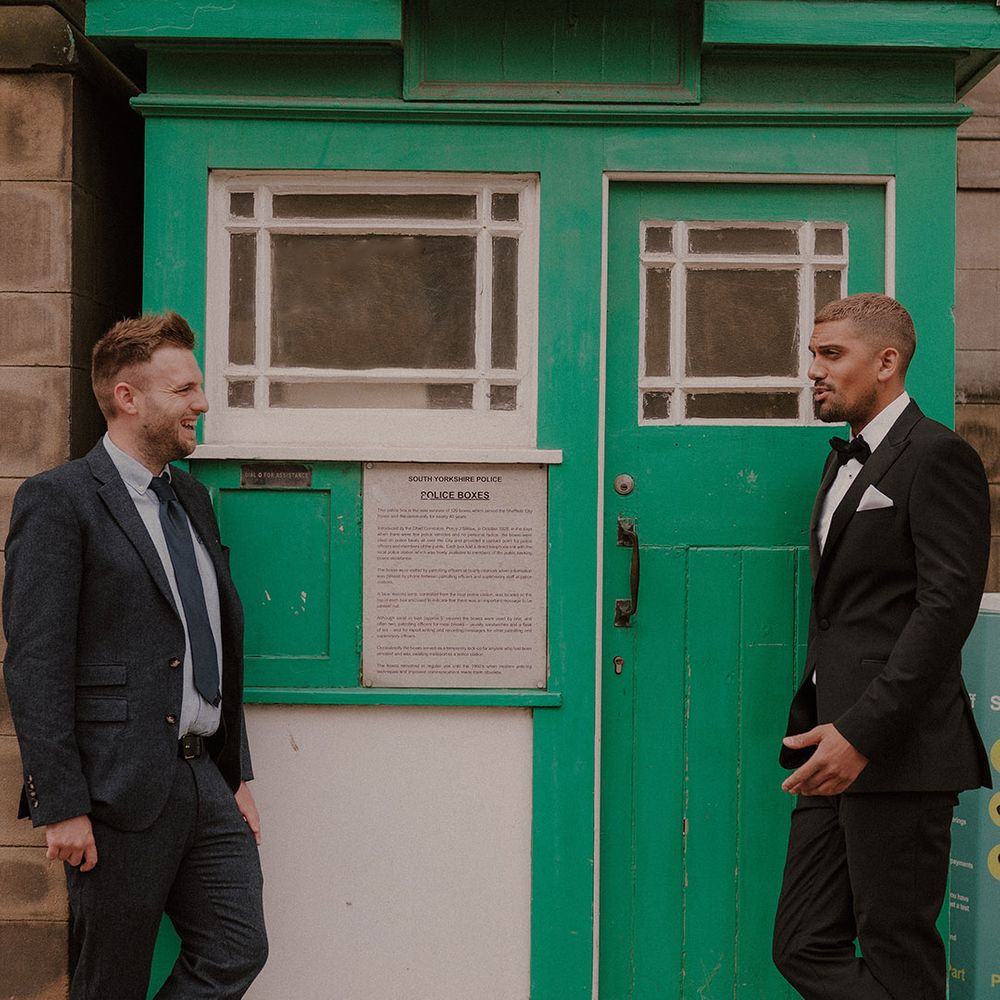 Groom in a tuxedo standing outside a South Yorkshire Police box