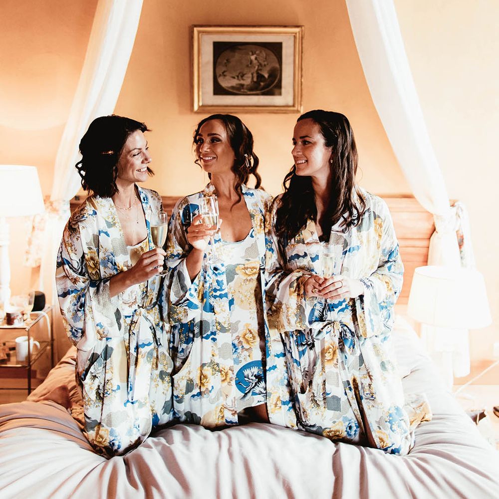 Bride sits with her bridesmaids on the morning of her wedding day wearing matching floral pyjama set