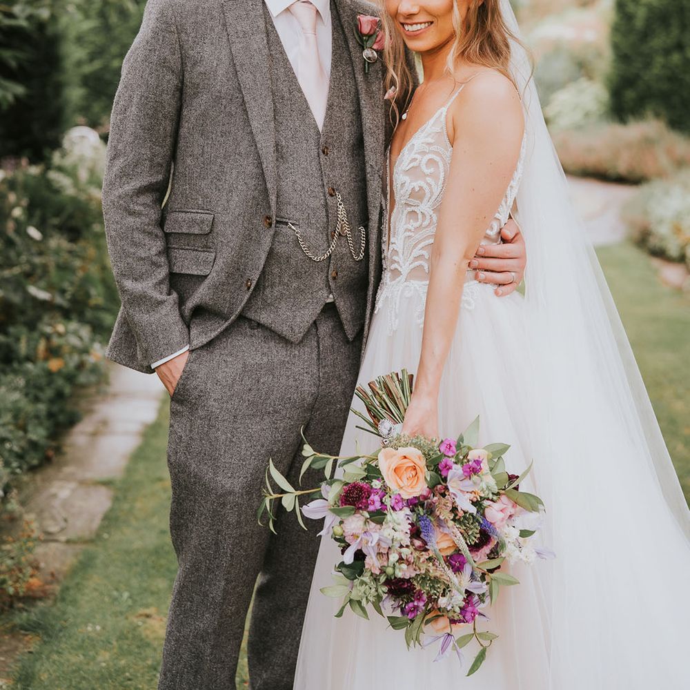 Bride and groom smile together at outdoor country house wedding venue