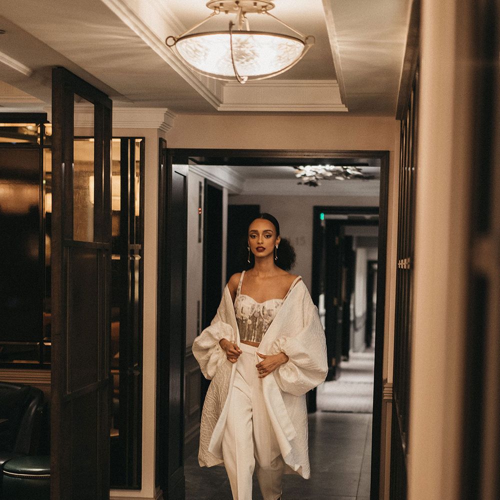 Black bride in trousers, corset top and wedding coat for contemporary city wedding at Mayfair Townhouse 