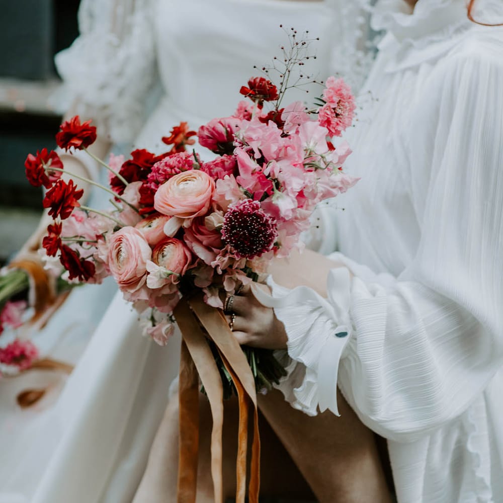 romantic pink and red wedding bouquet with sweet peas and butterfly ranunculus flowers 