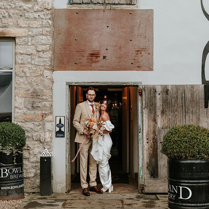 Bride and groom pose together at their industrial wedding venue, Holmes Mill