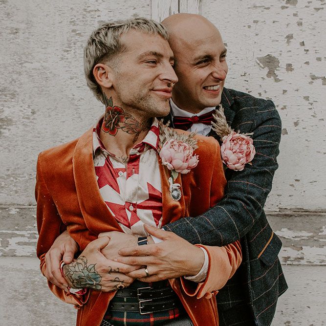 Groom wears orange blazer complete with homemade floral buttonholes 