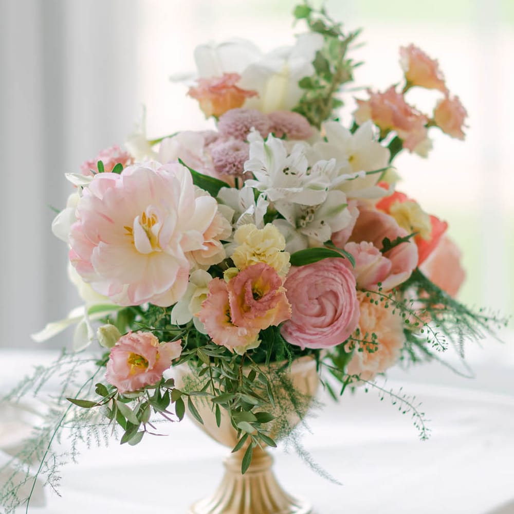 Pastel pink, yellow and white wedding flower arrangements for the wedding tables 