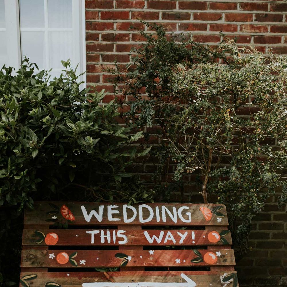 DIY wooden wedding sign with painted on wording and orange details