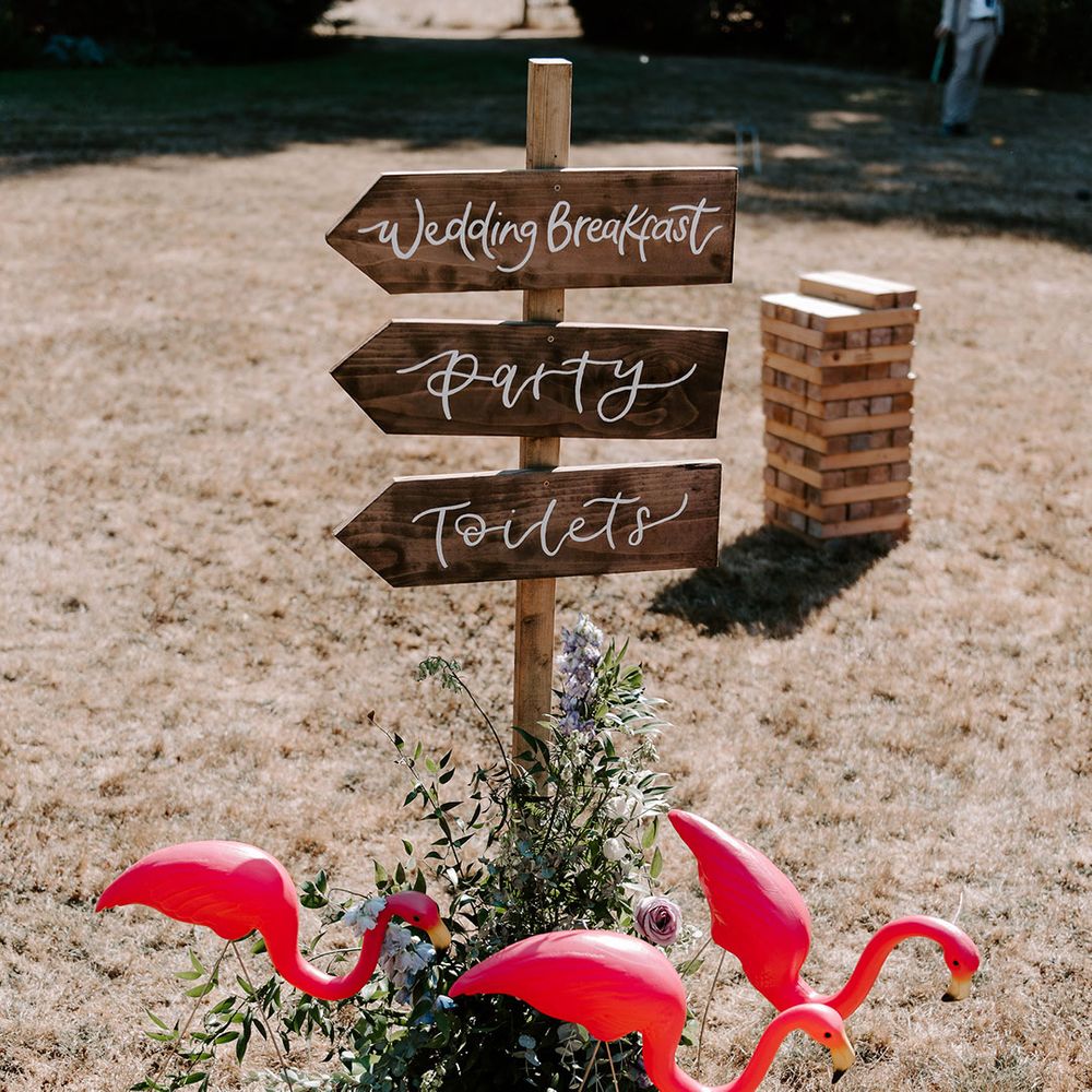 Wooden wedding sign with lawn flamingo decorations for Ibiza pool party theme 