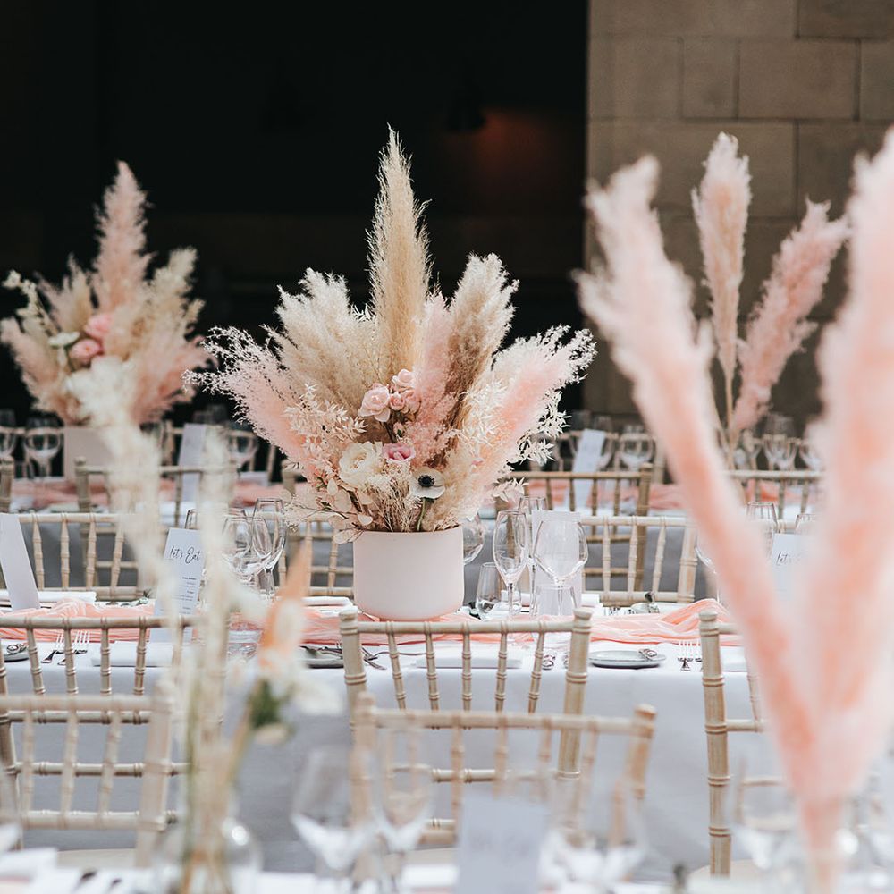 Modern and boho wedding reception with white and pink pampas centrepiece decor at Hampton Manor 