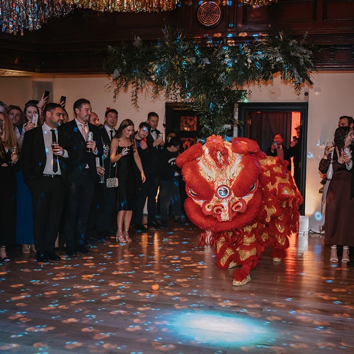 Wedding guests watching Chinese Lion Dance at multicultural Christmas wedding in London