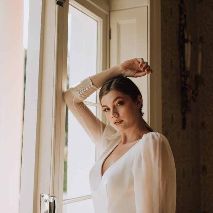 Bride wears long sleeve wedding dress with button cuffs